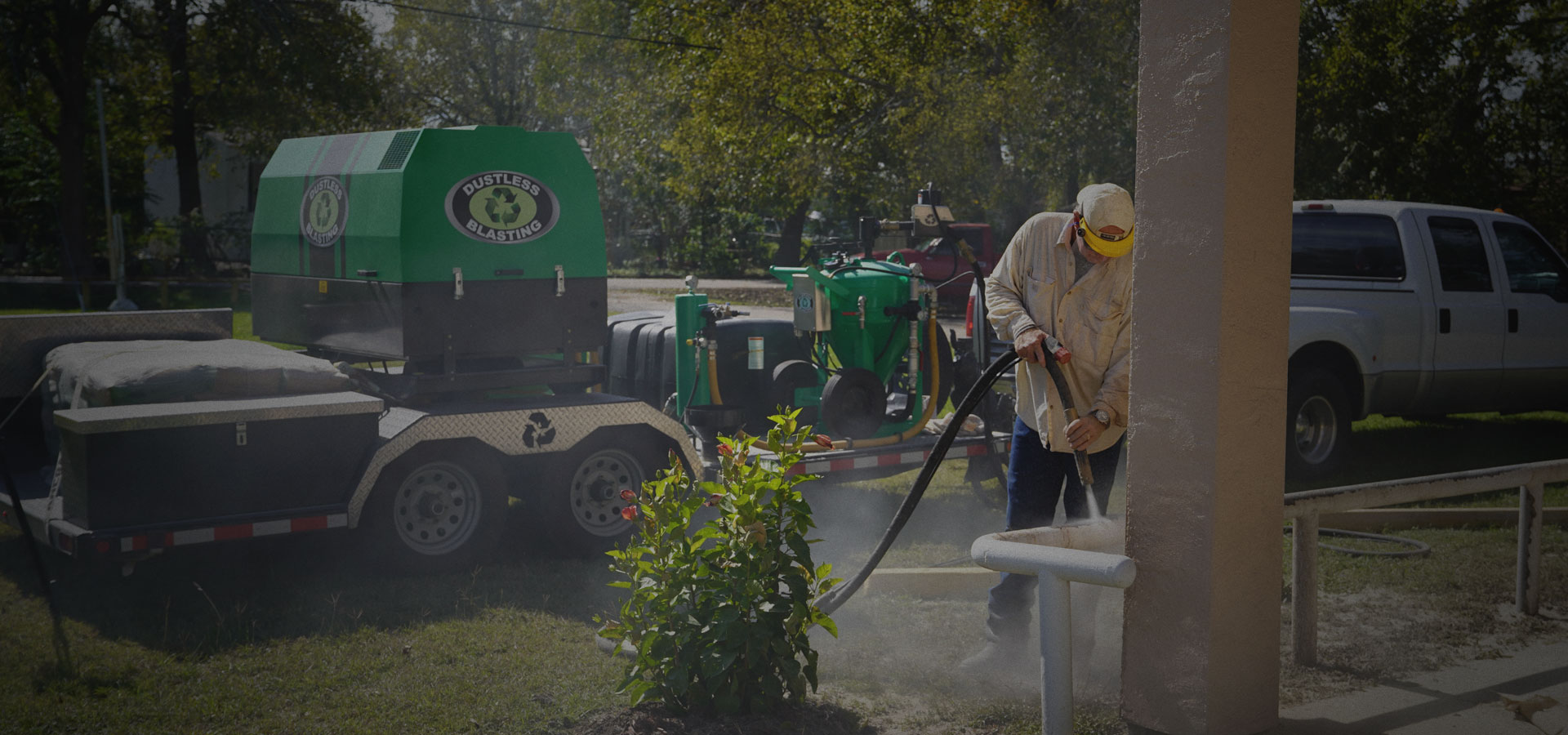 A DeFonzo technician dustless blasting on site next to the mobile Dustless Blasting rig